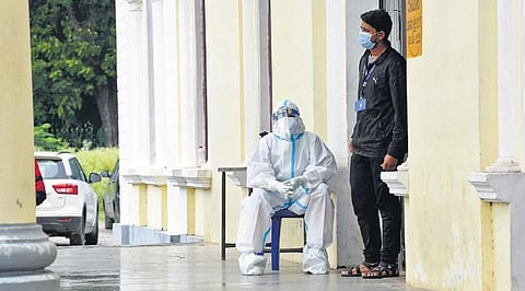 Health workers wait for patients at a Covid-19 testing booth on a rainy  Wednesday in Mysuru | udayshankar s