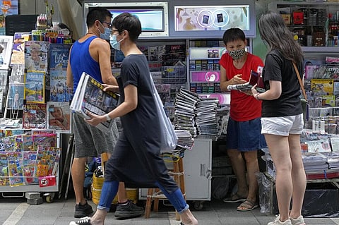 People buy Apple Daily at a downtown street in Hong Kong Friday, June 18, 2021. (Photo | AP)