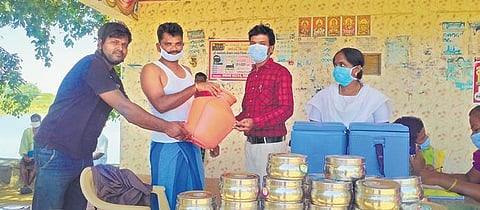 Thambidurai presenting a gift to a villager for taking vaccine | Express