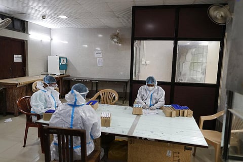 Technicians list COVID-19 test samples collected after receiving samples from different parts of the city at Moti Lal Nehru medical college in Prayagraj. (Photo | AP)