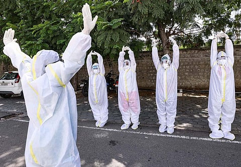 COVID-19 patients wearing PPE kit perform yoga on International Day of Yoga, at Codissia in Coimbatore. (Photo | PTI)