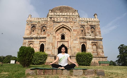A morning walker performs yoga on the occasion of  International Yoga Day at Lodhi garden in New Delhi. (Photo | Parveen Negi