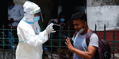 A health worker collects swab samples of a passenger at Krantivira Sangolli Rayanna  Railway Station in Bengaluru on Sunday. (Photo | Shriram BN, EPS)