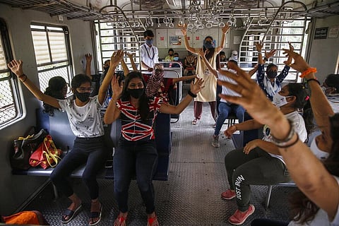 Commuters in a suburban train take part in a yoga session held to mark International Yoga Day in Mumbai. (Photo | AP)