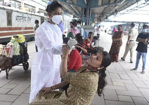 A BMC health worker collects swab sample of a passenger for COVID-19 testing, at Dadar railway station in Mumbai, Tuesday, June 22, 2021.  (Photo | PTI)