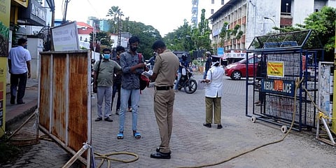 Kerala Police officials checking passes for employees to enter Ernakulam market. (Photo | A Sanesh, EPS)