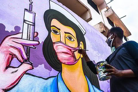 An artist busy painting on walls on the theme of COVID-19 in Bhubaneswar (File photo| Biswanath Swain, EPS)