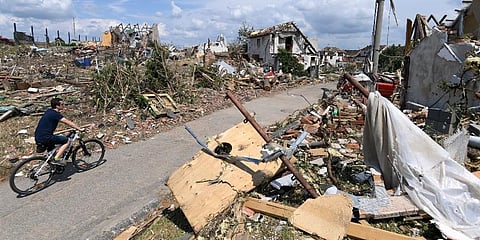 Man rides his bike after a tornado hit the village of Mikulcice in the Hodonin district, South Moravia, Czech Republic. (Photo | AP)