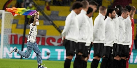 A fan with a LGBT pride flag runs on the pitch during the national anthems before the Euro 2020 group F match between Germany and Hungary at the Allianz Arena in Munich. (Photo | AP)