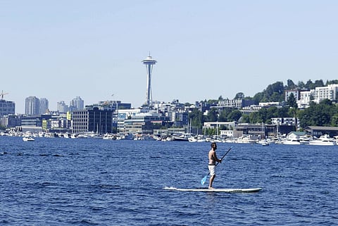 A person rides on a paddle board on Lake Union during a heat wave hitting the Pacific Northwest in Seattle. (Photo | AP)
