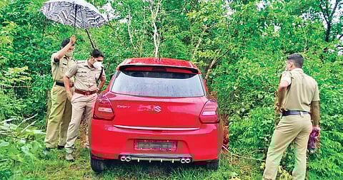 Police inspect the car found hidden atop a hill at Kulappuram near Taliparamba. (Photo| EPS)