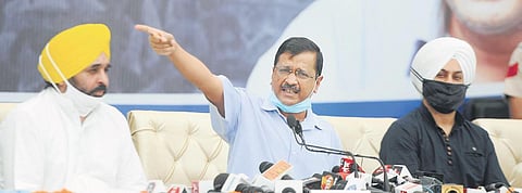 Delhi Chief Minister Arvind Kejriwal (C) with Punjab AAP chief Bhagwant Mann (L) at a press conference in Chandigarh. 