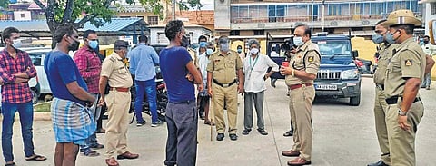 Police officers question sanitation workers regarding the death of three men