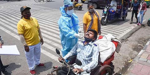 A medic collects a swab sample from a man for Covid-19 testing, in New Delhi. (Photo | PTI)