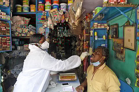 A health worker takes swab sample of a shop keeper, after the lockdown relaxions in Chennai. (Photo | R Satish Babu, EPS)