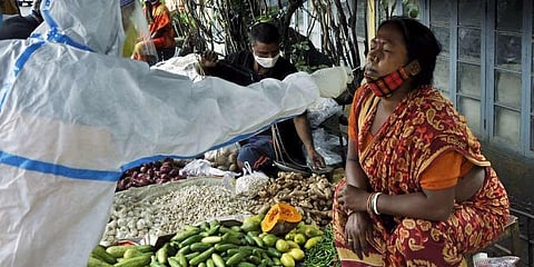 A healthcare worker collects a nasal sample of a street vendor for the COVID-19. (Photo | PTI)