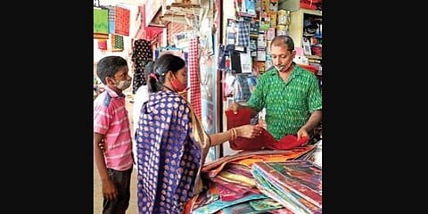 A woman looks at sarees at a shop in Bhubaneswar on Tuesday. (Photo | Irfana, EPS)