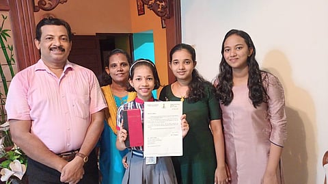Lidwina Joseph with her family showing the letter and gift she received (Photo | Special arrangement)