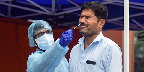 A health worker in PPE takes swab samples of a man for RT PCR COVID-19 test. Representational Image (File Photo | ANI)