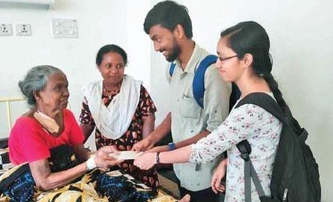 Students handing over aid to a beneficiary