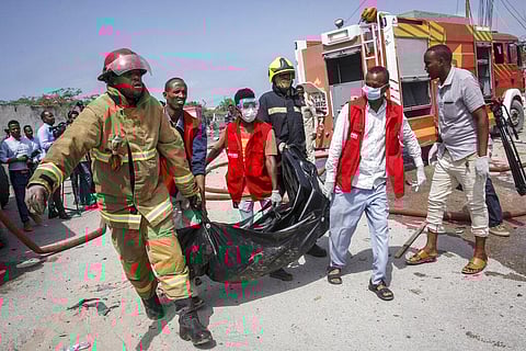 Medical workers carry the body of a civilian who was killed in a suicide car bomb attack that targeted the city's police commissioner in Mogadishu, Somalia Saturday, July 10, 2021. (Photo | AP)
