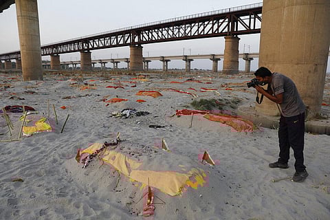 Bodies of suspected Covid-19 victims are seen in shallow graves buried in the sand near a cremation ground on the banks of Ganges River in Prayagraj. (Photo | AP)