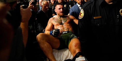 Conor McGregor is carried off on a stretcher after losing to Dustin Poirier in a UFC 264 lightweight mixed martial arts in Las Vegas. (Photo | AP)