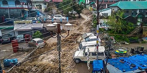 Flood water surges through a street amid heavy rain after a cloudburst, at Mcleodganj near Dharamshala (Photo | PTI)