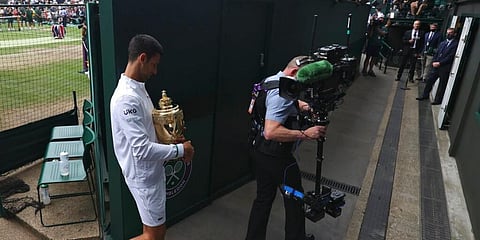 Serbia's Novak Djokovic holds his winner's trophy and leaves the court after the presentation ceremony for the men's singles final of the Wimbledon Tennis Championships, July 11, 2021. (Photo | AP)