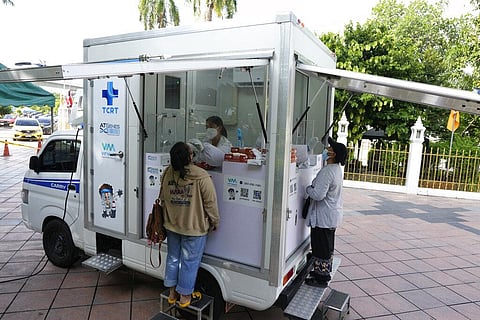Health workers collect nasal swabs from locals who were waiting through the night for free coronavirus testing at Wat Phra Si Mahathat temple in Bangkok. (Photo | AP)