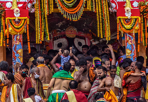 A baby servitor, sitting on his father’s shoulders, pays obeisance to Lord Jagannath on Nandighosha chariot during Rath Yatra. (Photo | Biswanath Swain, EPS)