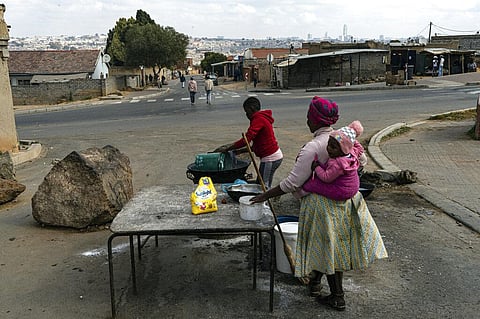 Women pack up their roadside food stall in Alexandra Township, north of Johannesburg. (Photo | AP)