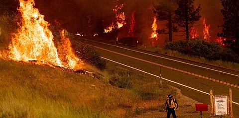 A firefighter walks towards a home while battling the Tamarack Fire in the Markleeville community of Alpine County, Calif., on Saturday, July 17, 2021. (Photo | AP)