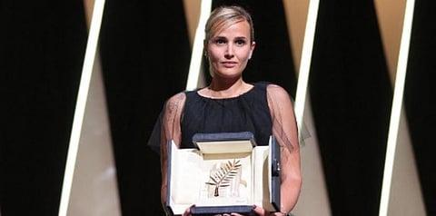 French director Julia Ducournau on stage with her trophy after she won the Palme d'Or for her film 'Titane' during the closing ceremony of the 74th edition of the Cannes Film Festival. (Photo | AFP)