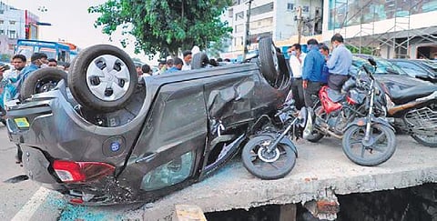 Onlookers watch as a newly-purchased car fell from the first floor of the showroom in LB Nagar, Hyderabad, on Monday. (Photo | Express)