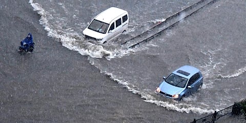 Vehicles pass through floodwaters in Zhengzhou in central China's Henan Province on Tuesday. (Photo| AP)