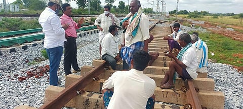 Farmers protesting at the railway tracks in Rangepalli on Tuesday against the acquisition of their land for SWR's Yelahanka-Penujonda doubling project (Photo | Special arrangement)