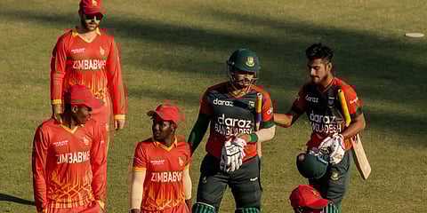 Bangladesh's batsman Nurul Hasan (C) and teammate Mohammad Naim(R) walk back to the pavilion with Zimbabwean fielders after victory in the first T20I match. (Photo| AFP)
