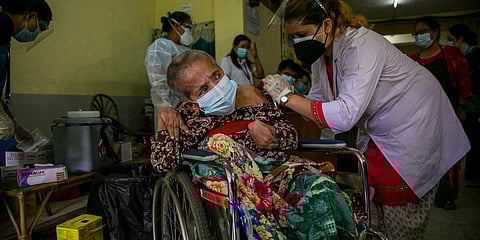 An elderly physically disabled Nepalese woman receives a dose of Johnson and Johnson vaccine at the Nepal Disabled Association Khagendra New Life Center in Kathmandu. (Photo| AP)