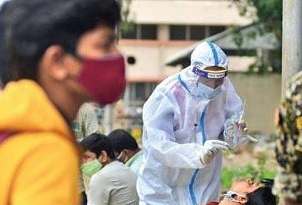 A health worker collects swab samples of a passenger at Majestic bus stand in Bengaluru on Wednesday | SHRIRAM BN