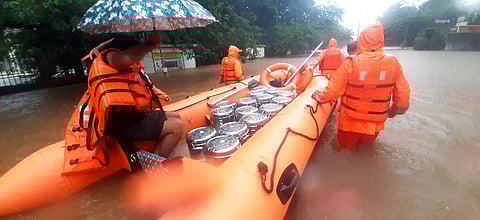 This photograph provided by India's National Disaster Response Force (NDRF) shows NDRF personnel carrying food boxes for residents in Chiplun area in Maharashtra. (Photo | AP)