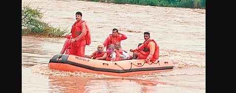 An NDRF team rescues seven persons who were stranded at a Guru Ashram near Sawel village under Mendora mandal in Nizamabad district on Friday