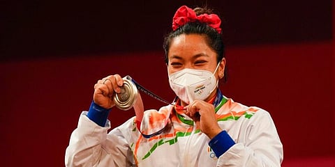 Chanu Saikhom Mirabai of India celebrates on the podium after winning the silver medal in the women's 49kg weightlifting event, at the 2020 Summer Olympics in Tokyo, Japan. (Photo | AP)