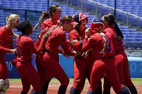 United States' Amanda Chidester, center, is mobbed by teammates after a game winning hit in the eighth inning of a softball game against Australia. (Photo | AP)