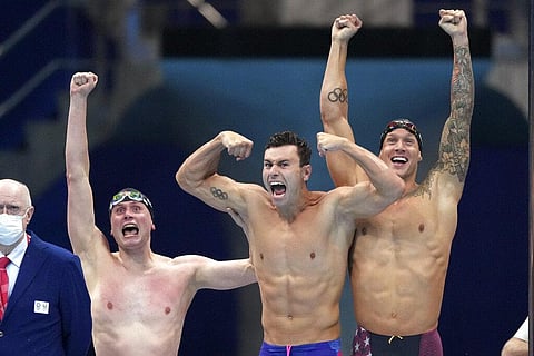 United States men's 4x100m freestyle relay team of Bowen Beck, Blake Pieroni, and Caeleb Dressel react after winning the gold medal at the 2020 Summer Olympics. (Photo | AP)