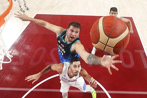 Slovenia's Luka Doncic top, fights for a rebound with Argentina's Luca Vildoza during a men's basketball preliminary round game at the 2020 Summer Olympics. (Photo | AP)