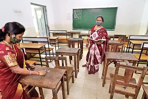 Teachers write down seat numbers on desks to maintain social distancing among students at a school in Bhubaneswar on Sunday | Irfana