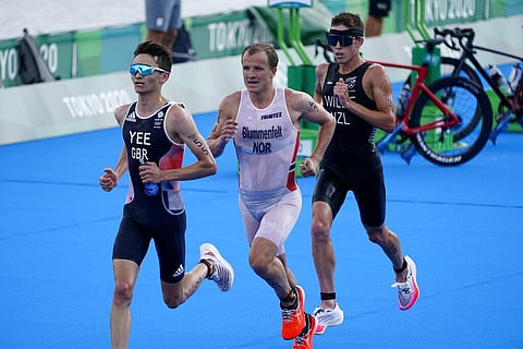 Alex Yee of Great Britain, Kristian Blummenfelt of Norway and Hayden Wilde of New Zealand run though the second transition during the men's individual triathlon. (Photo | AP)