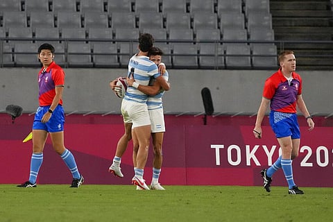 Argentina's Marcos Moneta, center right, celebrates with teammate Ignacio Mendy after scoring a try, in their men's rugby sevens quarterfinal match against South Africa. (Photo | AP)