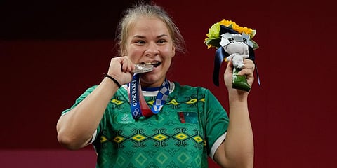 Polina Guryeva of Turkmenistan celebrates on the podium after winning the silver medal in the women's 59kg weightlifting event, at the 2020 Summer Olympics in Tokyo, Japan. (Photo | AP)